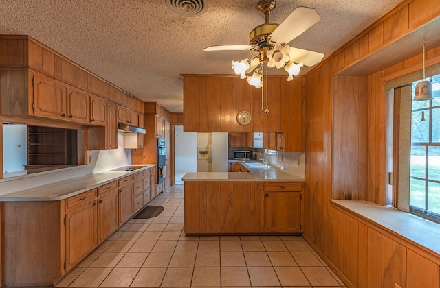 1345 10th St, Hempstead, TX 77445 - kitchen featuring a sink, white fridge with ice dispenser, stainless steel microwave, a peninsula, and under cabinet range hood