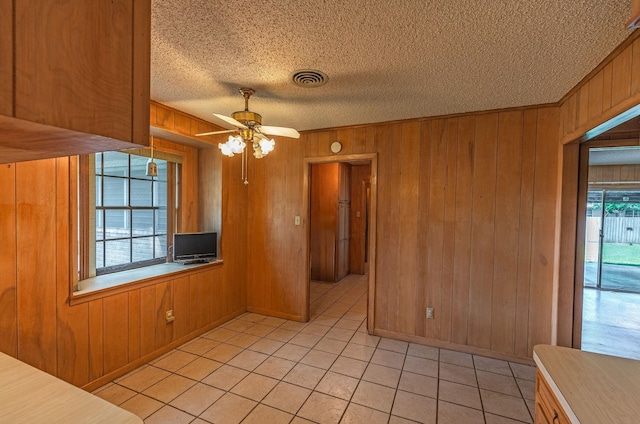 1345 10th St, Hempstead, TX 77445 - spare room with wood walls, light tile patterned flooring, a textured ceiling, and visible vents