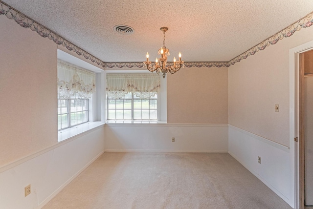 1345 10th St, Hempstead, TX 77445 - unfurnished room with visible vents, carpet flooring, a chandelier, and a textured ceiling