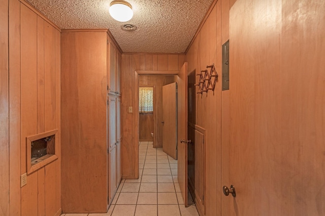 1345 10th St, Hempstead, TX 77445 - hallway featuring electric panel, wooden walls, a textured ceiling, and light tile patterned floors