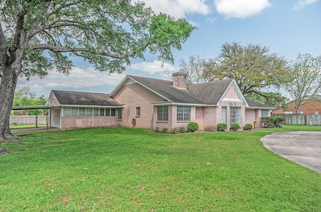 1345 10th St, Hempstead, TX 77445 - view of front of house featuring fence, a chimney, brick siding, and a front yard