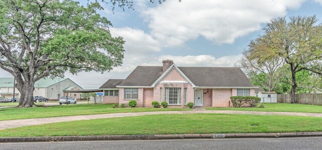 1345 10th St, Hempstead, TX 77445 - view of front of house featuring fence, a front lawn, brick siding, and a chimney