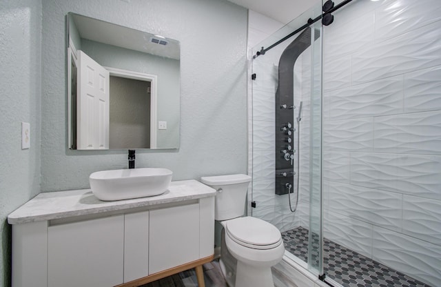 5823 Plantation Crest Dr, Katy, TX 77449 - bathroom with a textured wall, visible vents, toilet, vanity, and a stall shower
