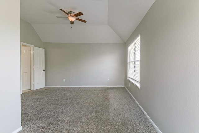 spare room featuring lofted ceiling, a ceiling fan, carpet flooring, and baseboards