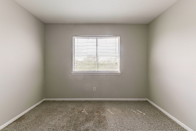 carpeted spare room featuring baseboards