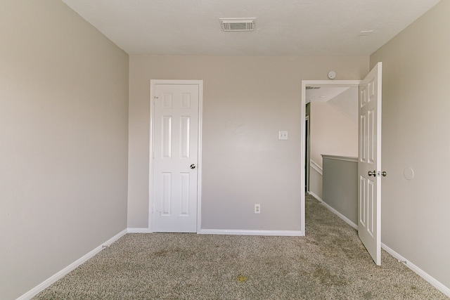 unfurnished bedroom featuring baseboards, carpet flooring, and visible vents