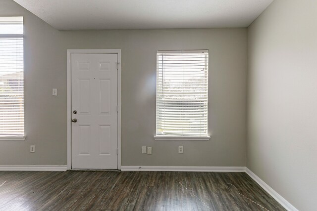 entryway featuring baseboards and dark wood finished floors