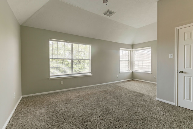 carpeted spare room featuring lofted ceiling, visible vents, and baseboards