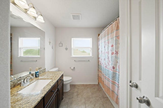 bathroom featuring plenty of natural light, visible vents, toilet, and vanity