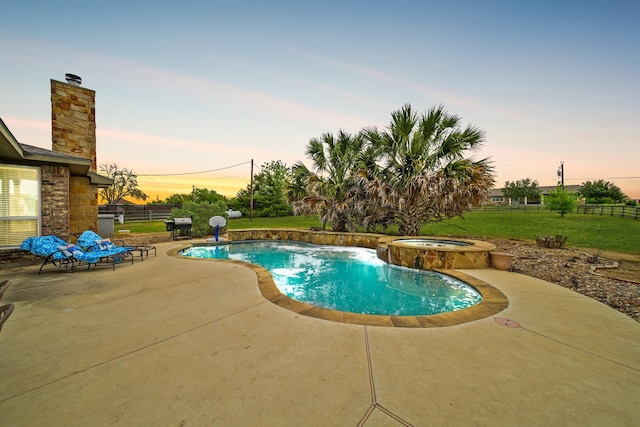 view of pool featuring fence, a patio area, grilling area, a lawn, and a pool with connected hot tub