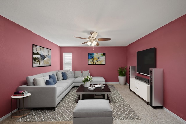 living area featuring baseboards, ceiling fan, and light colored carpet