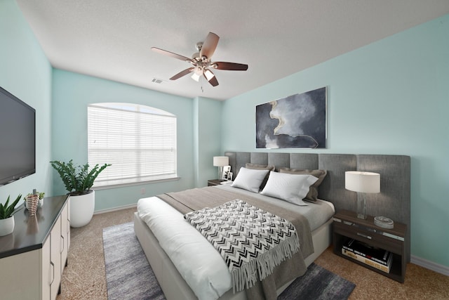 bedroom featuring ceiling fan, baseboards, visible vents, and carpet