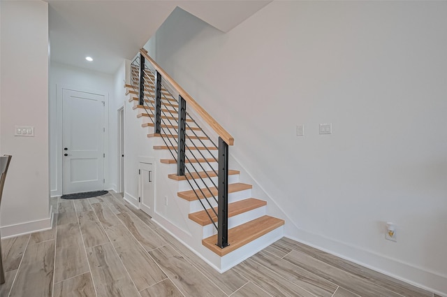 stairs featuring recessed lighting, wood finished floors, and baseboards