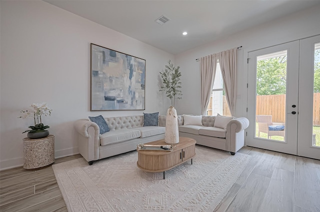 living area featuring light wood finished floors, french doors, baseboards, visible vents, and recessed lighting