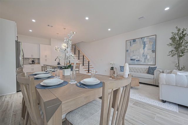 dining room with recessed lighting, visible vents, light wood finished floors, and stairs