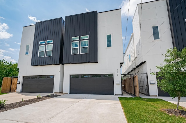 modern home featuring fence, driveway, board and batten siding, and a garage