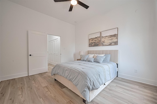 bedroom with ceiling fan, baseboards, and light wood-type flooring