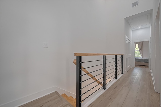 stairs featuring attic access, baseboards, wood finished floors, and visible vents