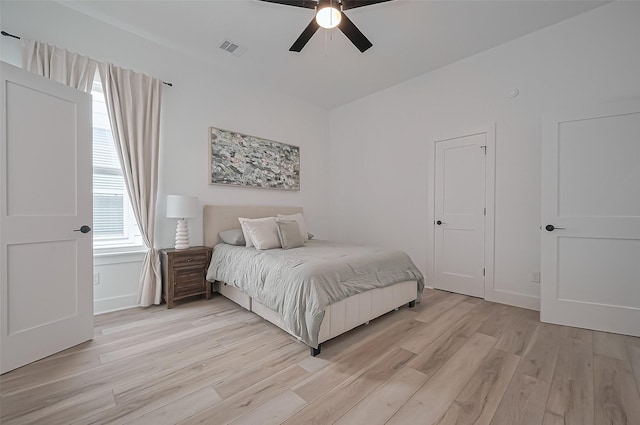 bedroom with visible vents, light wood finished floors, and a ceiling fan