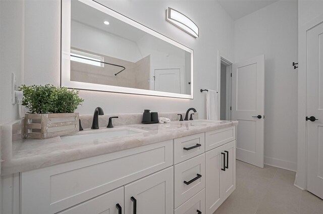 full bathroom featuring double vanity, tile patterned floors, a shower, and a sink