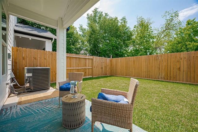 view of yard with a fenced backyard, central air condition unit, and a patio