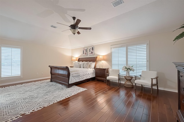 bedroom with lofted ceiling, visible vents, dark wood-style floors, and baseboards