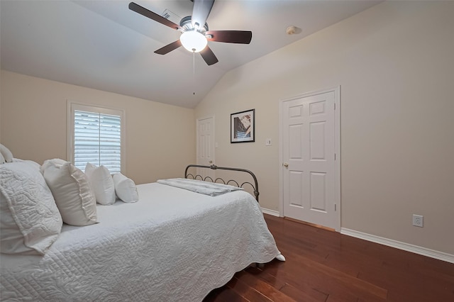bedroom with baseboards, ceiling fan, dark wood-style flooring, and vaulted ceiling