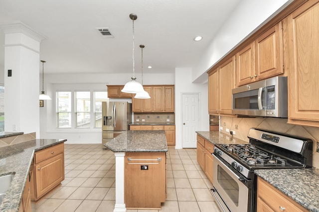 kitchen with a center island, decorative backsplash, light tile patterned flooring, stainless steel appliances, and visible vents