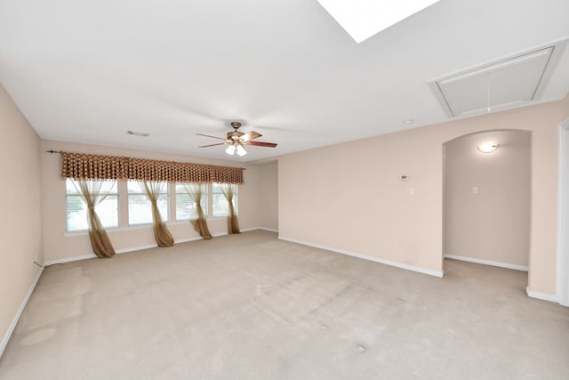 spare room featuring visible vents, a ceiling fan, baseboards, attic access, and light colored carpet