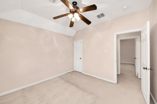 unfurnished bedroom with vaulted ceiling, visible vents, baseboards, and light carpet