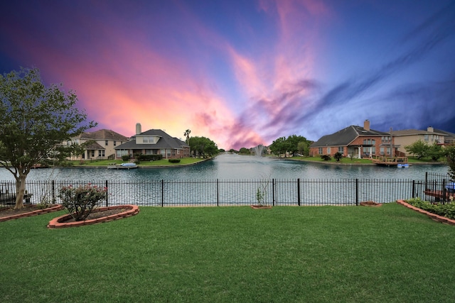 view of water feature with a residential view and fence