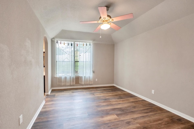 spare room with arched walkways, a ceiling fan, wood finished floors, and lofted ceiling