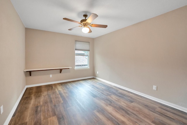 spare room featuring wood finished floors, a ceiling fan, and baseboards