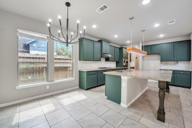kitchen featuring a sink, tasteful backsplash, visible vents, an inviting chandelier, and under cabinet range hood