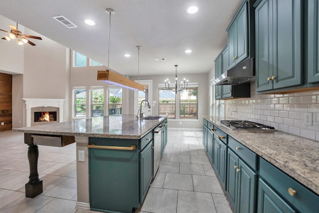 kitchen featuring under cabinet range hood, visible vents, a sink, appliances with stainless steel finishes, and open floor plan