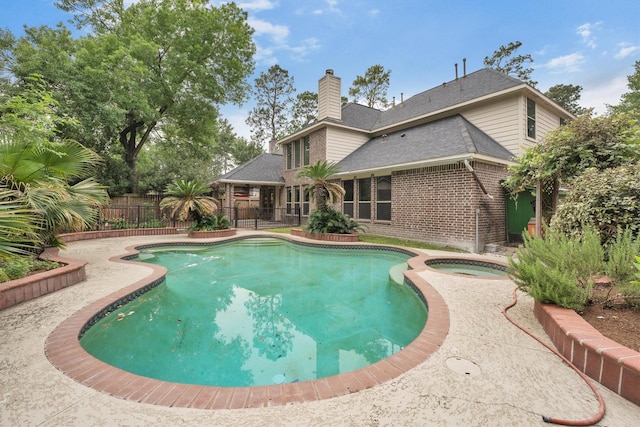 view of pool with fence, a patio area, a fenced in pool, and an in ground hot tub