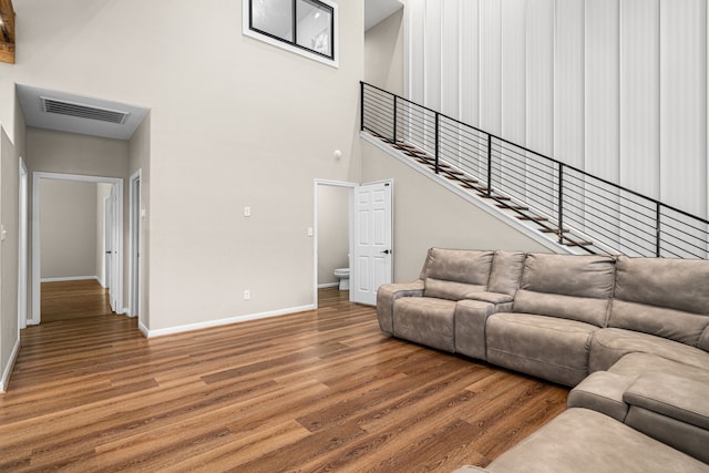 living area featuring wood finished floors, visible vents, and baseboards