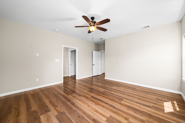 unfurnished room with baseboards, a ceiling fan, wood finished floors, and visible vents