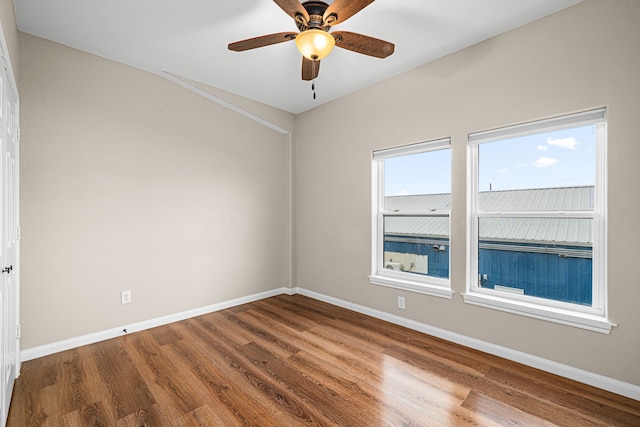 unfurnished room with ceiling fan, baseboards, and wood finished floors