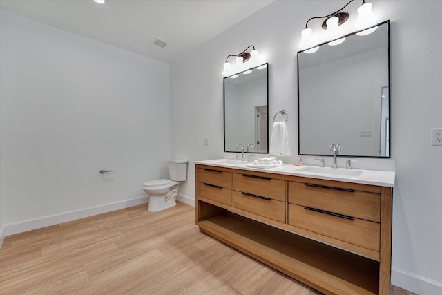 11571 Robin Ln, Conroe, TX 77303 - bathroom featuring wood finished floors, visible vents, a sink, and toilet