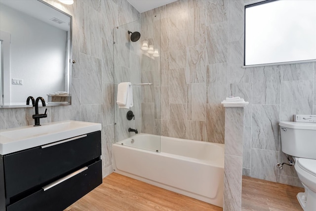 11571 Robin Ln, Conroe, TX 77303 - full bath with toilet, tile walls, shower / bathtub combination, visible vents, and vanity