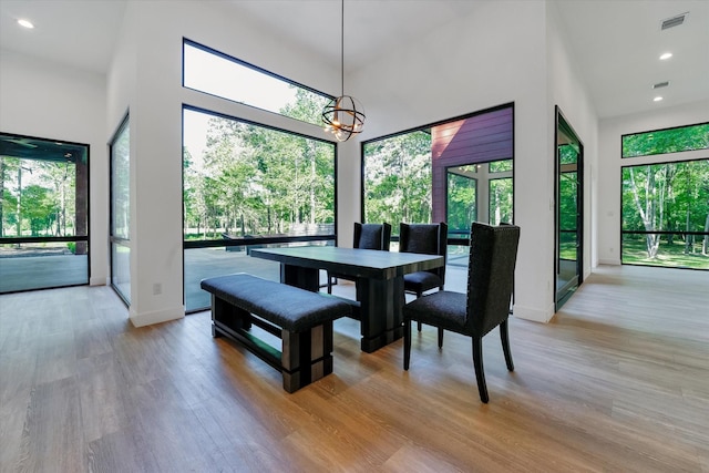 11571 Robin Ln, Conroe, TX 77303 - dining area featuring light wood finished floors, an inviting chandelier, and a healthy amount of sunlight