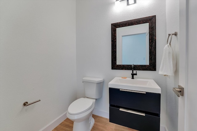11571 Robin Ln, Conroe, TX 77303 - bathroom featuring baseboards, wood finished floors, vanity, and toilet