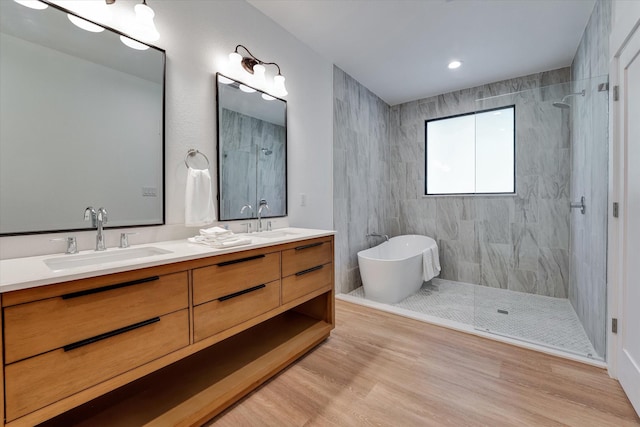 11571 Robin Ln, Conroe, TX 77303 - bathroom featuring wood finished floors, a sink, double vanity, and tiled shower