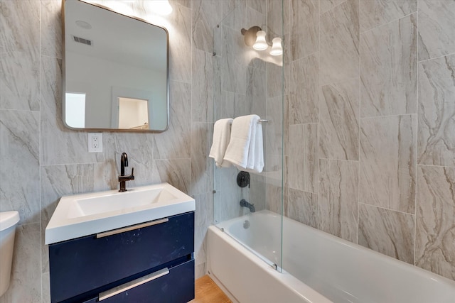 11571 Robin Ln, Conroe, TX 77303 - full bath with toilet, tile walls, visible vents, vanity, and tub / shower combination