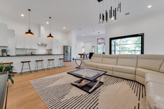 11571 Robin Ln, Conroe, TX 77303 - living area featuring a high ceiling, recessed lighting, visible vents, and light wood-type flooring