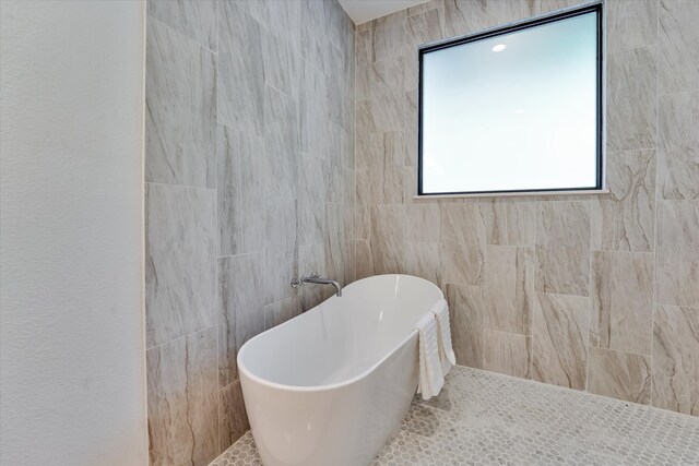 11571 Robin Ln, Conroe, TX 77303 - bathroom featuring a freestanding tub and tile walls
