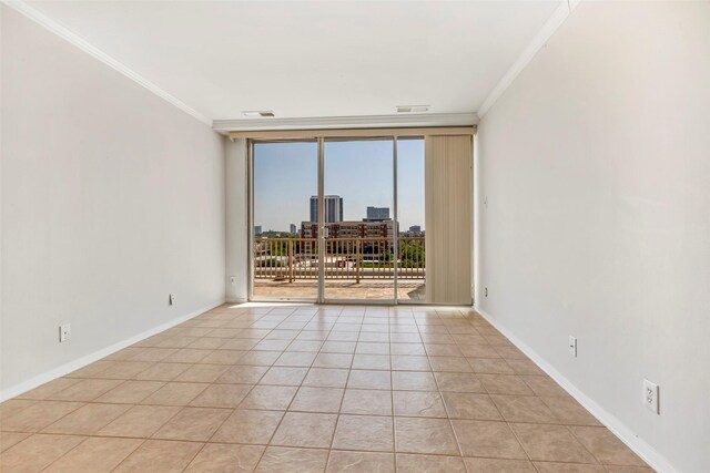 empty room featuring expansive windows, baseboards, ornamental molding, and light tile patterned floors