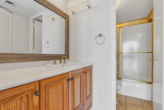 full bath featuring tile patterned floors, vanity, visible vents, toilet, and shower / bath combination with glass door