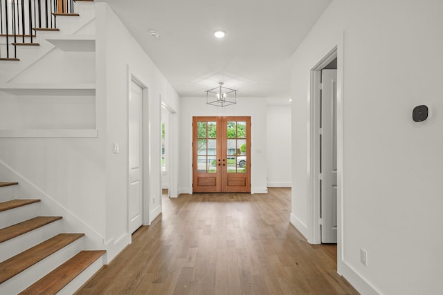 foyer with recessed lighting, baseboards, wood finished floors, and stairway